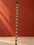An elegant sculptural floor lamp distinguished by its slender vertical silhouette and rhythmic arrangement of elongated...
