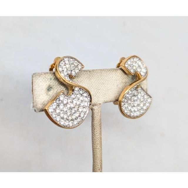 1980s goldtone pavé round clear rhinestones in the shape of twisted Ss clip earrings. Marked "GIVENCHY© PARIS NEW YORK" on...