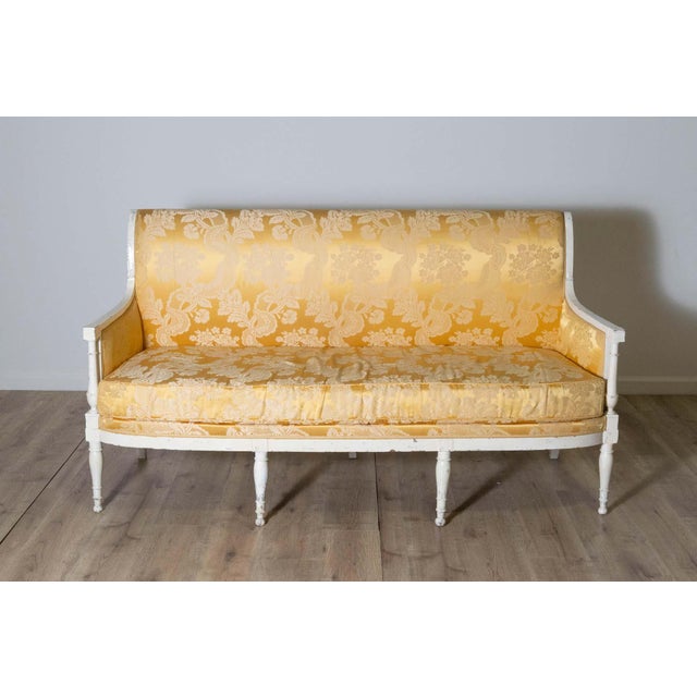An elegant 18th-century French canapé, showcasing the refined craftsmanship and timeless style of the Louis XVI period....