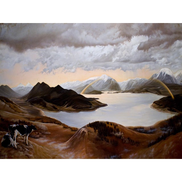 This oil painting presents a serene landscape dominated by rolling mountains and a tranquil lake, bathed in soft, warm...