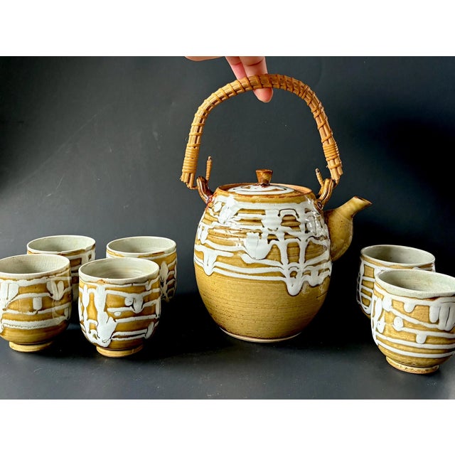 A beautiful midcentury Japanese stoneware tea set featuring a hand-applied drip glaze in warm earthy tones, reflecting the...