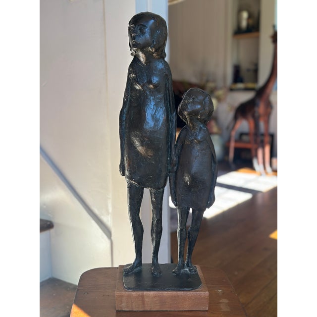 This striking, mid-century modern bronze sculpture features an stylized depiction of a mother and child standing side by...