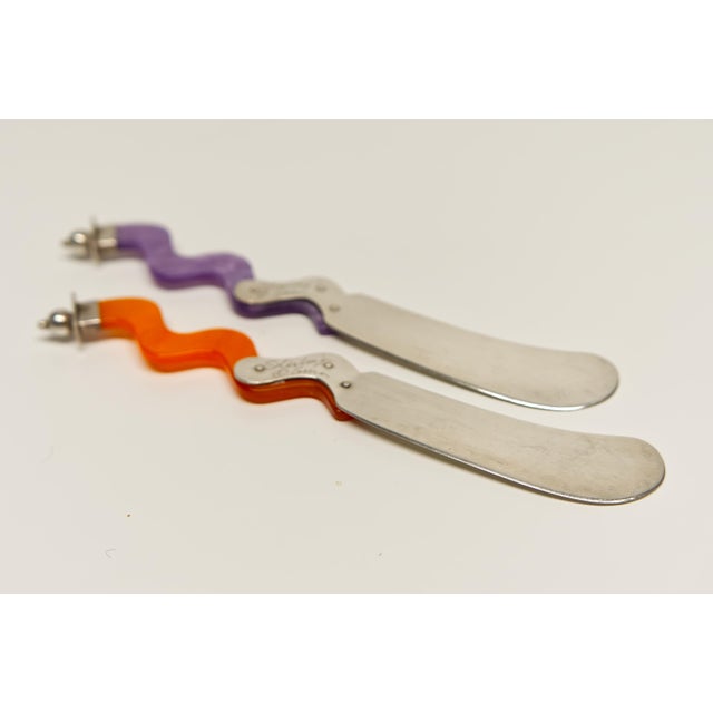 This pair of Postmodern style cheese spreaders features sleek sterling silver blades paired with distinctive wavy Lucite...