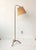 A floor lamp designed Paavo Tynell (1890-1973) model no. 9609. Lacquered metal, brass and wood slats Edition Taito Oy....