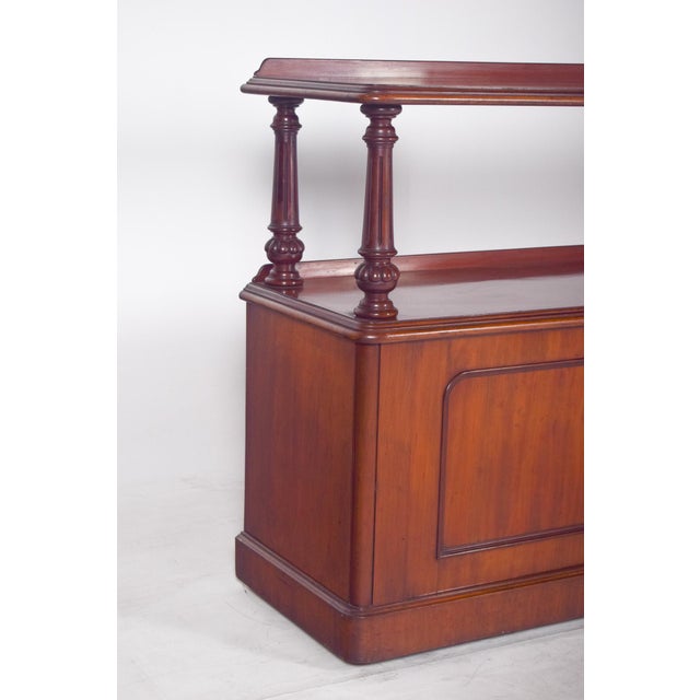 English dumbwaiter with turned columns. with two shelves, an upper one with slightly raised edges and a wider middle one,...
