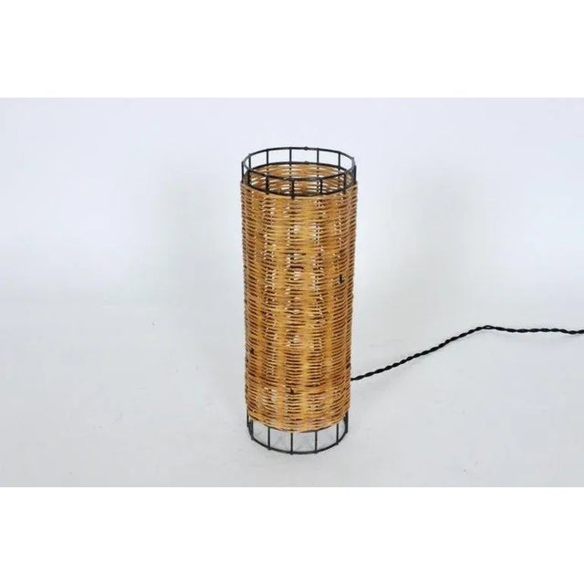 California Modern Paul Mayen for Habitat style narrow, cylinder Rattan and Wire Table Lamp. Featuring a cylindrical black...