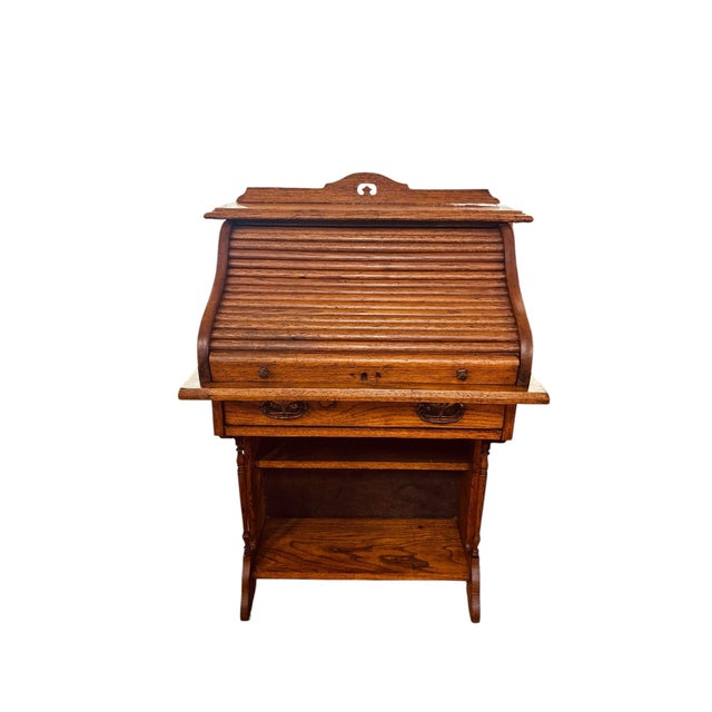 Charming antique Victorian child’s roll top desk crafted in oak and accompanied by a mix matched chair from around the...