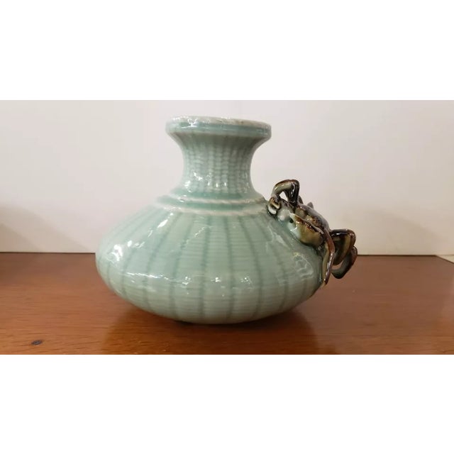 This is a Circa 1970 Chinese Celadon Porcelain Crab/Fishnet Pattern Vase. It measures 6 1/4" high and 7 1/2“ wide. The...