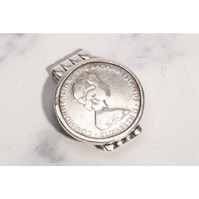 A bold and substantial vintage accessory, this sterling silver money clip is centered by an impressive 1971 Bahamas $5...