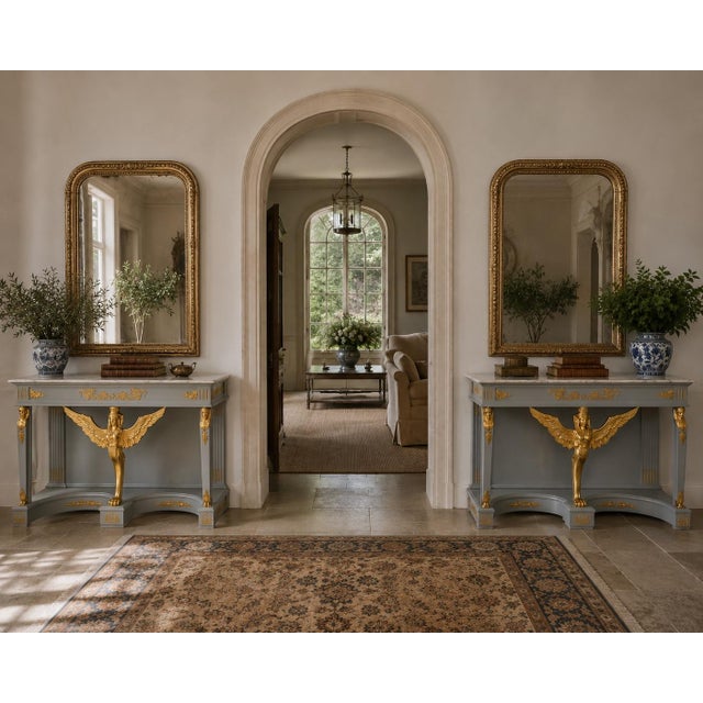 Elegant and theatrical, this pair of Neoclassical Empire console tables captures the enduring appeal of French Empire...
