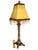 An ornate buffet-style table lamp featuring a slender barley-twist column, raised leaf and scroll motifs, and a sculptural...