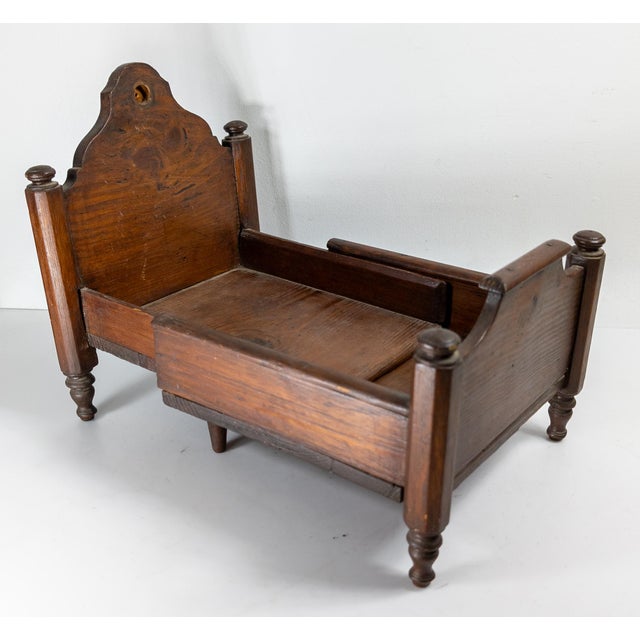 We are selling this interesting folk art Doll’s bed. This bed has sophisticated Empire or Plantation style carving on this...