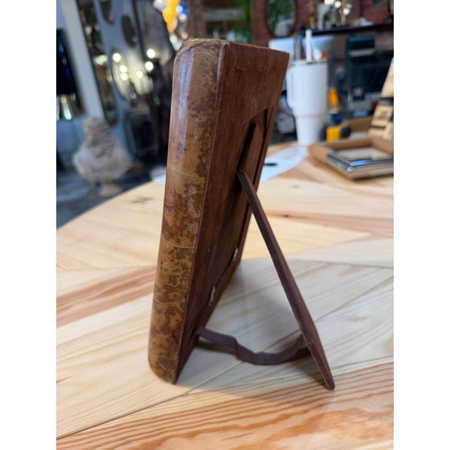 Rectangular picture frame featuring a broad, softly rounded border with a glossy amber and brown finish. Its mottled...