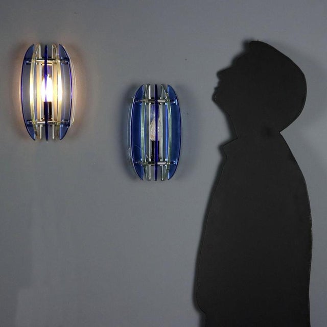 Two vintage wall lamps in two-tone blue and clear glass with a chrome metal base. Each lamp has an E14 base. This piece is...