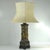 A large, highly decorative table lamp in an oriental style. It is made of patinated and locally gilded metal and sits on a...