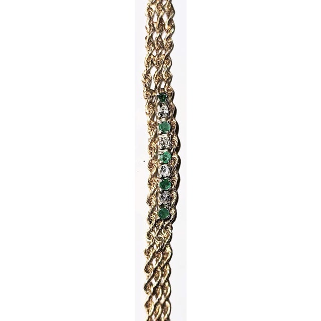 Lovely 14k gold triple rope bracelet adorned with 5 emeralds and 4 diamonds with a patented clasp, slightly over 7" long....
