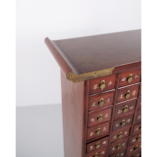 Antique apothecary cabinet in dark wood with 69 drawers and brass fittings. Korean style from around 1910. Decorative and...
