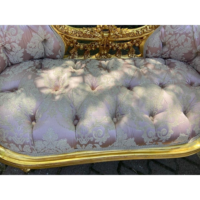 A graceful 1970s French Louis XVI-style settee, handcrafted from solid beech wood with a luminous gold leaf finish and...