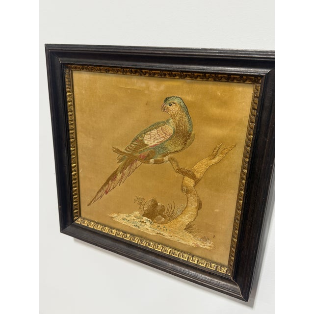 This finely executed silk embroidery depicts a parrot perched in profile upon a branching limb, presented with an elegant...