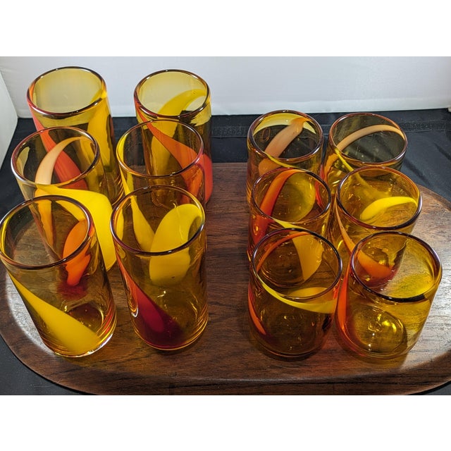 This is a set of 1990s vintage handblown amber glass tumblers, swirled with red and yellow reminiscent of amberina. Each...