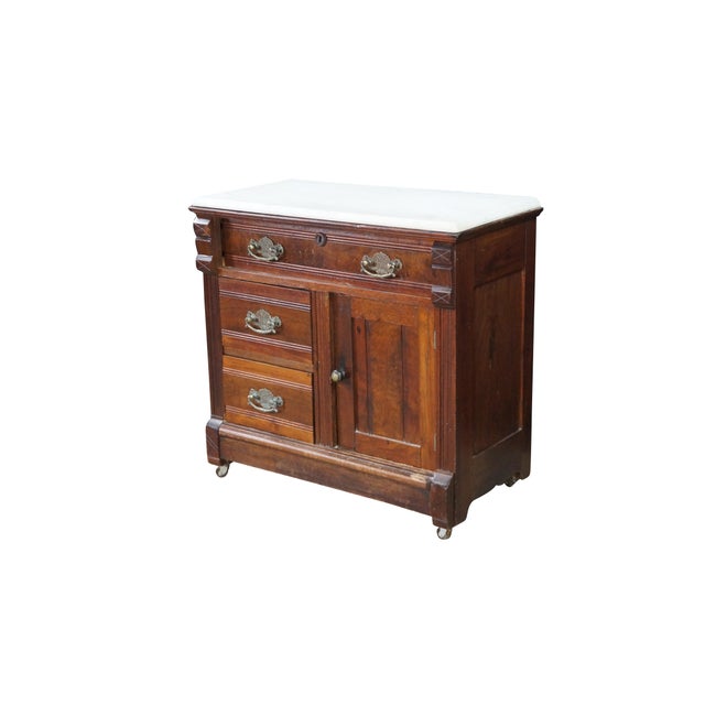 This antique Victorian Eastlake washstand is a classic late 19th-century bedroom piece constructed from rich walnut with...