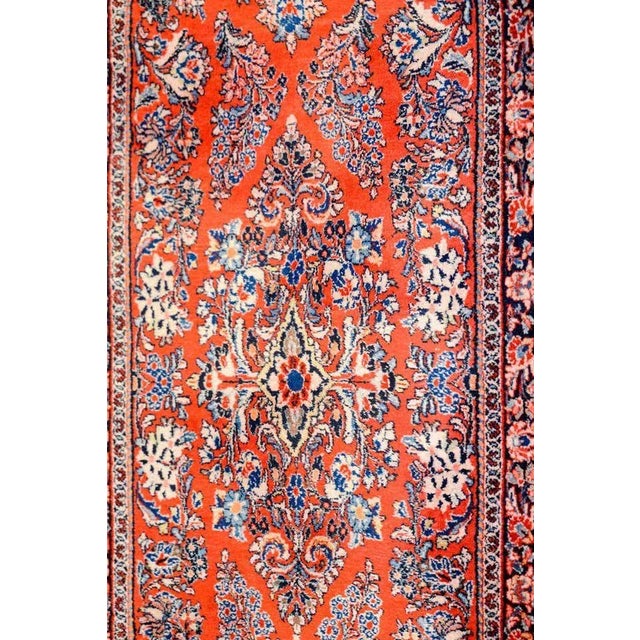 A beautiful early 20th century Persian Sarouk rug with a beautiful mirrored floral pattern woven in light and dark indigo,...