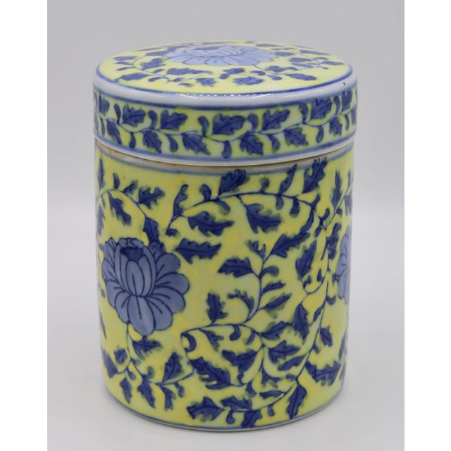 A stunning mid-20th century lidded porcelain jar with a canary yellow background, and blue flora and fauna design. Very...