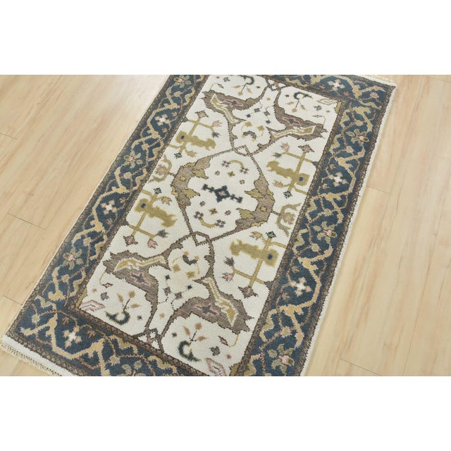 A modern tribal Oushak rug hand-knotted with an all-wool pile on a cotton foundation. This oriental rug features a central...