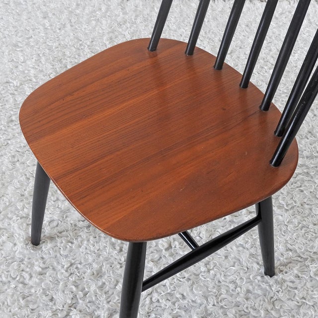 Typical Nordic chair with a slatted back (Pinnstolar). Ebonized back and legs. Solid teak seat with an ergonomic shape....
