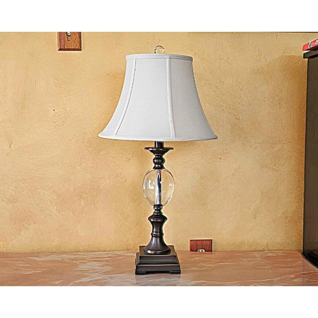 A refined crystal and metal urn table lamp showcasing timeless elegance and modern luminosity. This piece features a...