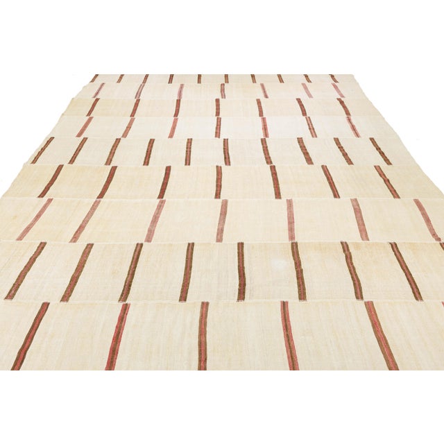 This exceptional 13 x 27 vintage Kilim rug is a rare find, offering an expansive, minimalist aesthetic that anchors large...