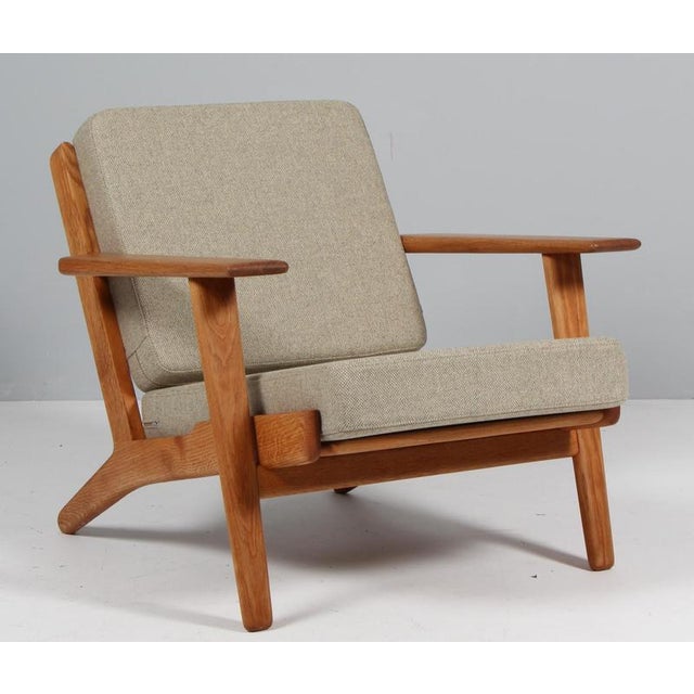 Hans J. Wegner lounge chair made of solid oiled oak. New upholstered with Lillehammer wool from Nevotex. Model 290, made...