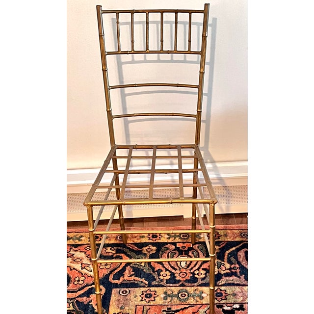 Vintage gilt iron faux bamboo side chair, made in Spain. This charming piece features classic Chiavari styling rendered in...