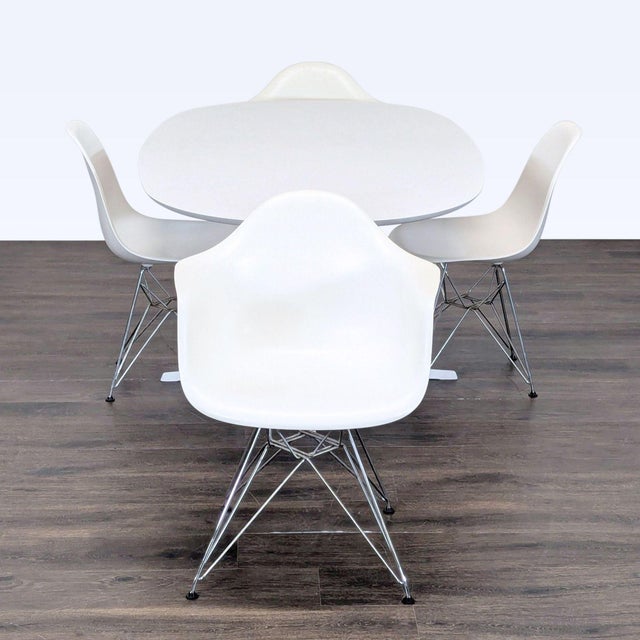 This Eames Dining Set includes an elegant white oval table with a sturdy pedestal base and four matching white chairs. The...