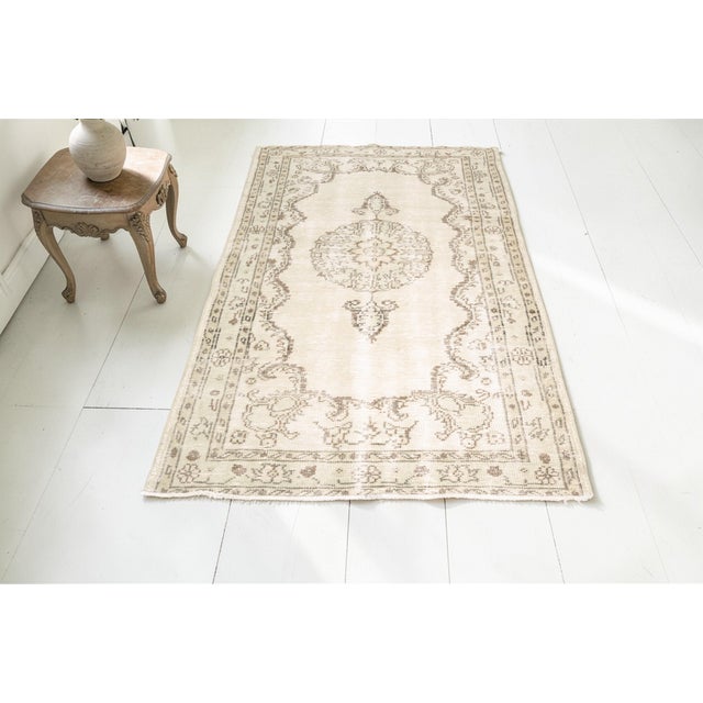 This is a vintage Turkish Oushak rug from the Mid 20th Century. The piece was hand-knotted.