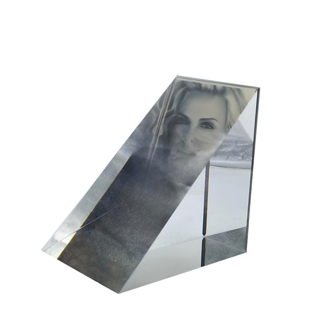 An elegant photo frame or portrait sculpture in transparent methacrylate, reflecting the formal and geometric exploration...