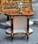 Elegant French Louis XVI-style oval étagère table featuring a richly finished wood structure with ornate gilt bronze and...