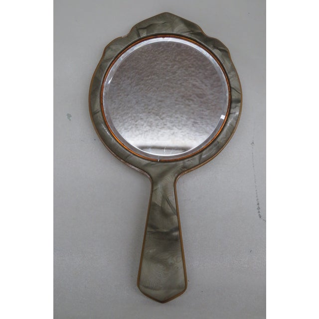 This magnificent Hand Held Mirror is made out of bakelite and glass. This Vanity Mirror has exquisite Art Deco style...