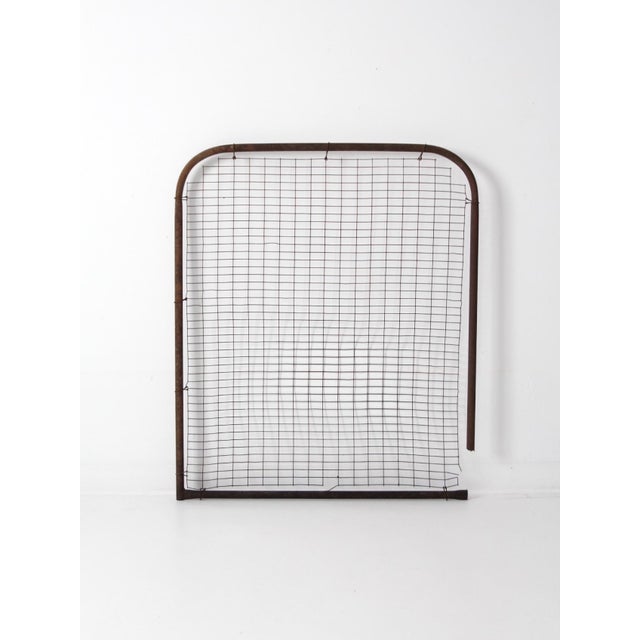 This early 20th century industrial wire gate panel features a rounded steel pipe frame and a square grid center. The...
