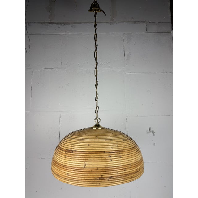 A wonderful large brown pencil or split reed rattan wicker bamboo pendant lamp with brass, Italy 1970s. The rattan is...