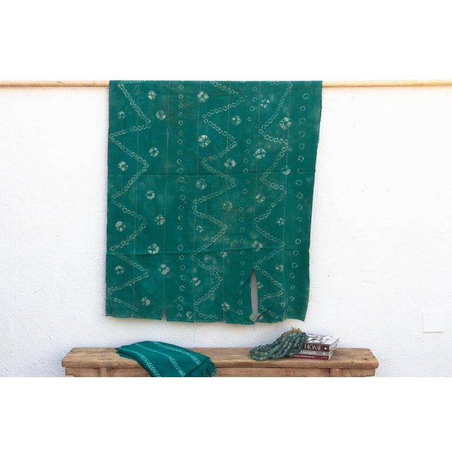 A rare regional variation of West African indigo, featuring saturated teal-green hues and hand-stitched details. This...