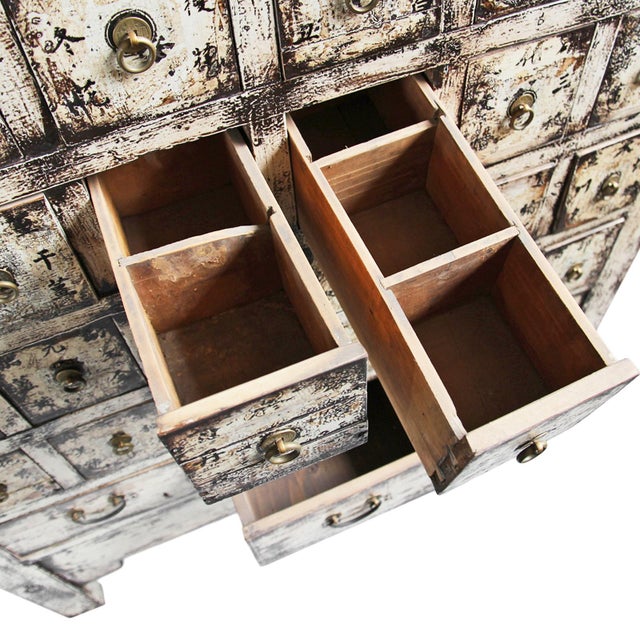 Antique aged white painted solid wood apothecary cabinet with multiple storage drawers. Original brass ring handles and...