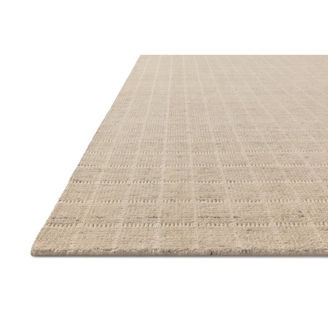 The Cedar Collection by Amber Lewis x Loloi is a hand-loomed area rug with a clean gridded design in contrasting ivory....