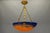 Refined french art nouveau pendant light featuring a richly mottled glass bowl in deep blue and warm amber-orange tones,...