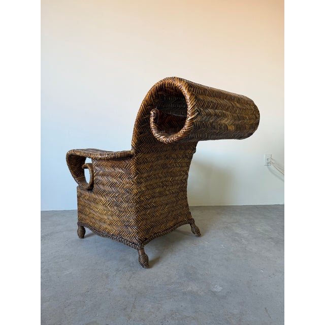 Striking vintage coastal lounge chair and matching ottoman crafted entirely in richly toned woven rattan. Featuring...