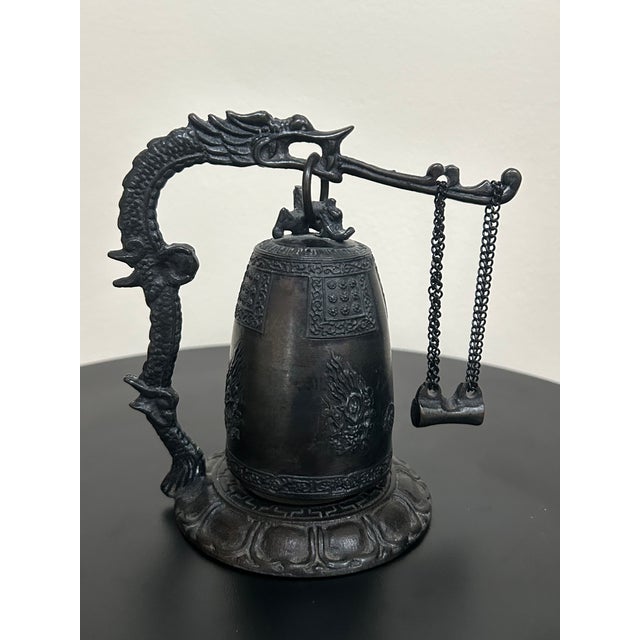 Vintage Japanese cast iron temple-style bell featuring an elaborate dragon-form support and suspended striker. Standing...