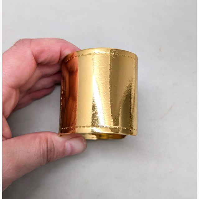 1980s goldtone with "stitching" slide on wide cuff bracelet. Marked "MONET ©" on the inside. Measures: 1 15/16 inches tall...