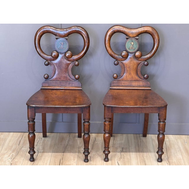 A pair of early 19th C. English late Regency or William IV mahogany hall chairs with shaped backs and solid seats, each...