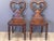A pair of early 19th C. English late Regency or William IV mahogany hall chairs with shaped backs and solid seats, each...