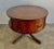 English leather top Drum table that stands on a four curved legs with carved acanthus leaf detail. The brown leather on...
